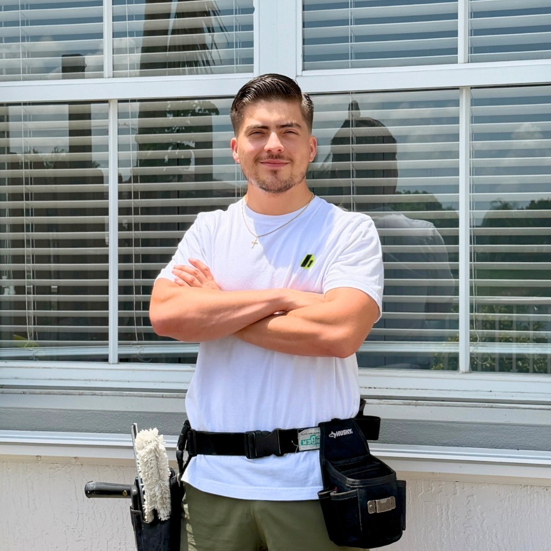 Cesar, owner of Glassy Window Cleaning, standing in front of a freshly cleaned home in Doral, FL